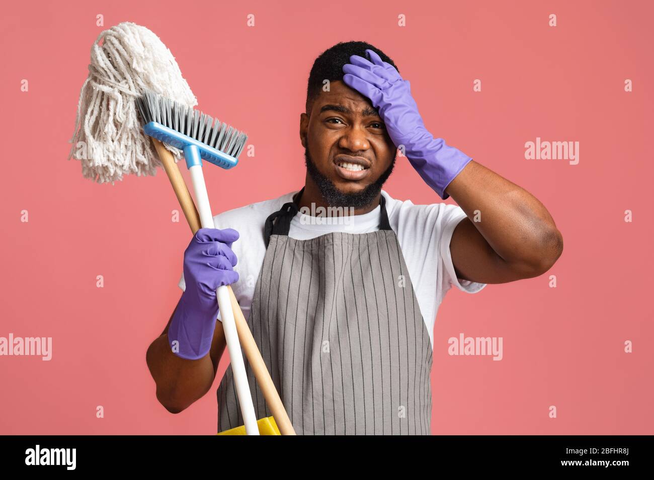 Worry African Man With Mop And Broom, Touching Head In Despair Stock