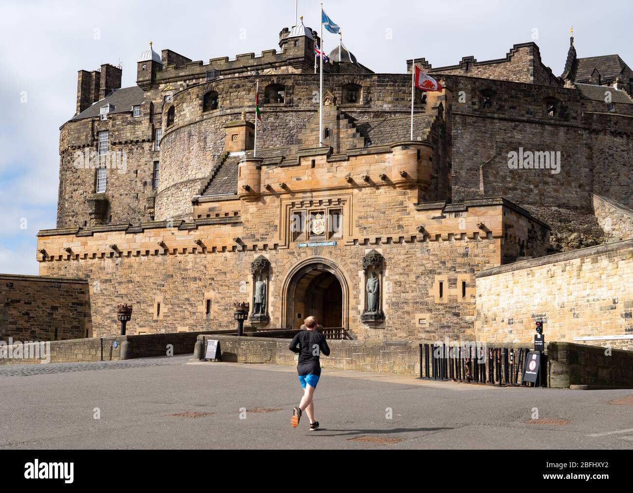 Edinburgh, Scotland, UK. 18 April 2020. Views of empty streets and members of the public outside on another Saturday during the coronavirus lockdown in Edinburgh. Esplanade of Edinburgh Castle is deserted with a few runners outside. . Iain Masterton/Alamy Live News Stock Photo