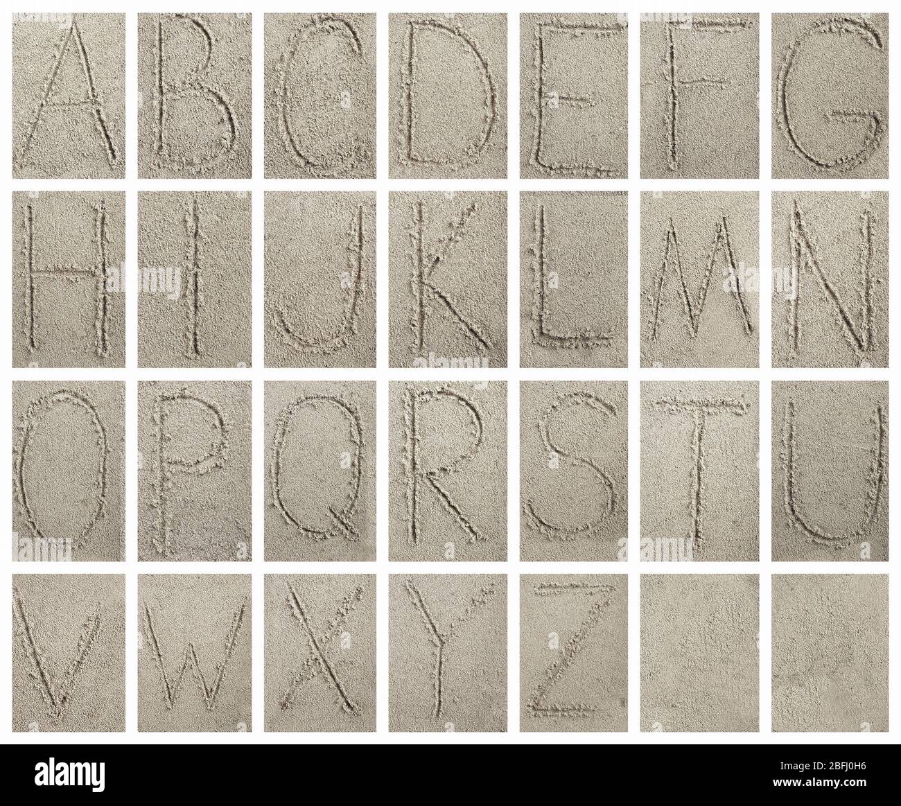 Handwritten alphabet letters on sand background Stock Photo - Alamy