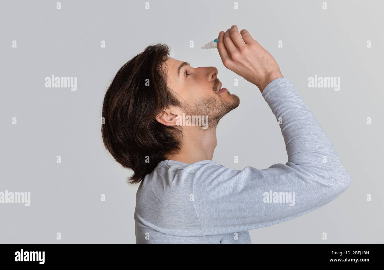 Dry in eyes. Guy dripping eye drops Stock Photo Alamy