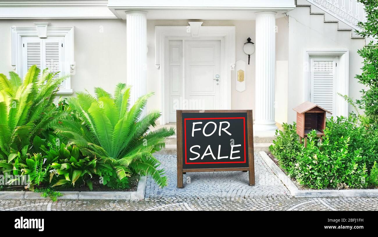 Real estate sign in front of new house for sale Stock Photo - Alamy