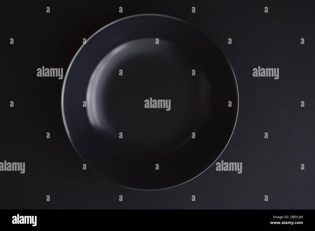 Empty plates on black background, premium dishware for holiday dinner ...