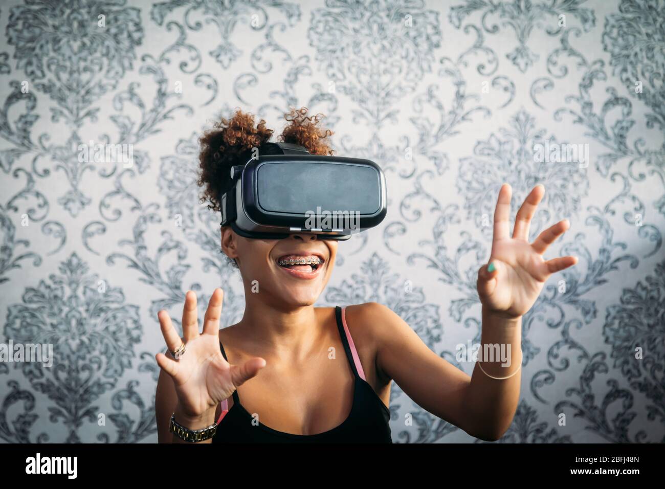 Portrait of a brunette girl with brackets wearing virtual reality ...