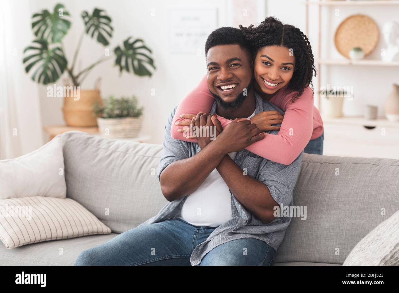 Happy Married Black Couple Cuddling At Home And Posing To Camera Stock