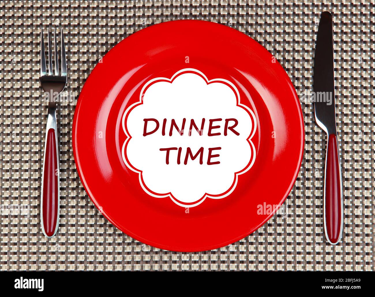 Plate with text Dinner Time, fork and knife on tablecloth background ...