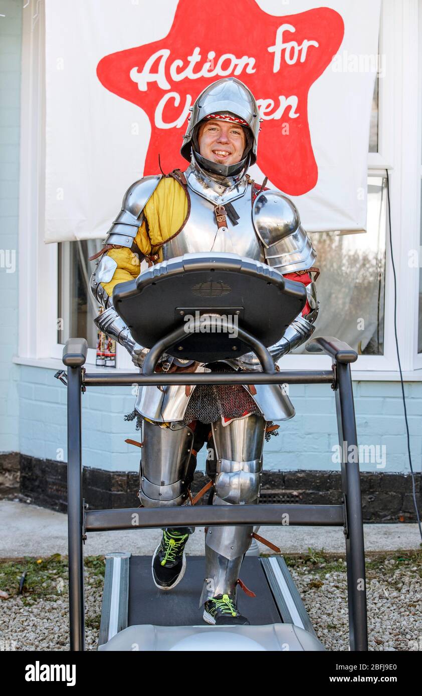 Mike Manders, 34, uses a treadmill in his front garden in Hull, dressed in a suit of armour as he attempts the postponed Hull 10k, whilst the UK continues in lockdown to help curb the spread of the coronavirus. Stock Photo