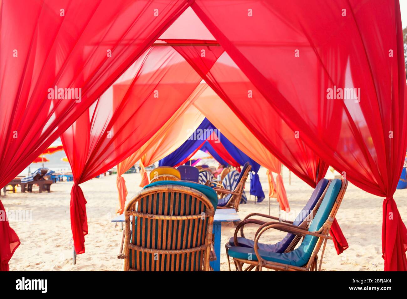 empty cafe with many colored canopy, baldachin tunnel looling on the seashore close to water in summer, India, Goa. Interior on summer restaurant on t Stock Photo
