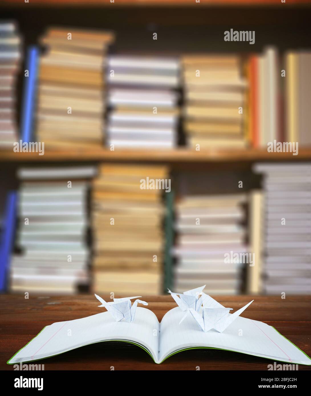Origami cranes with notebook on bookshelves background Stock Photo Alamy
