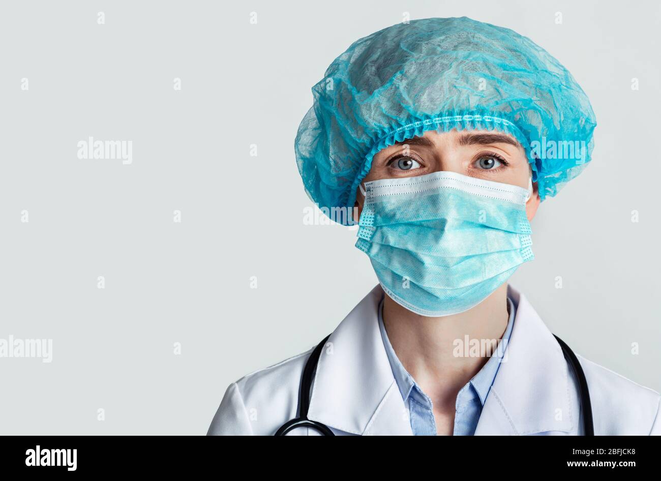 Therapist in protective mask and cap with stethoscope Stock Photo