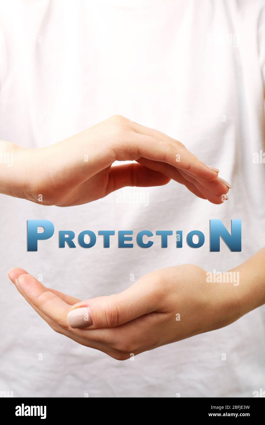 Female hands with word protection on light background Stock Photo