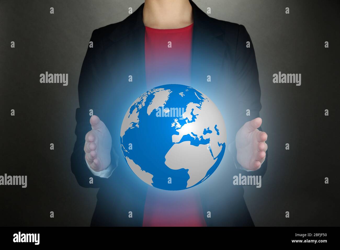 Female hands showing globe on dark background Stock Photo