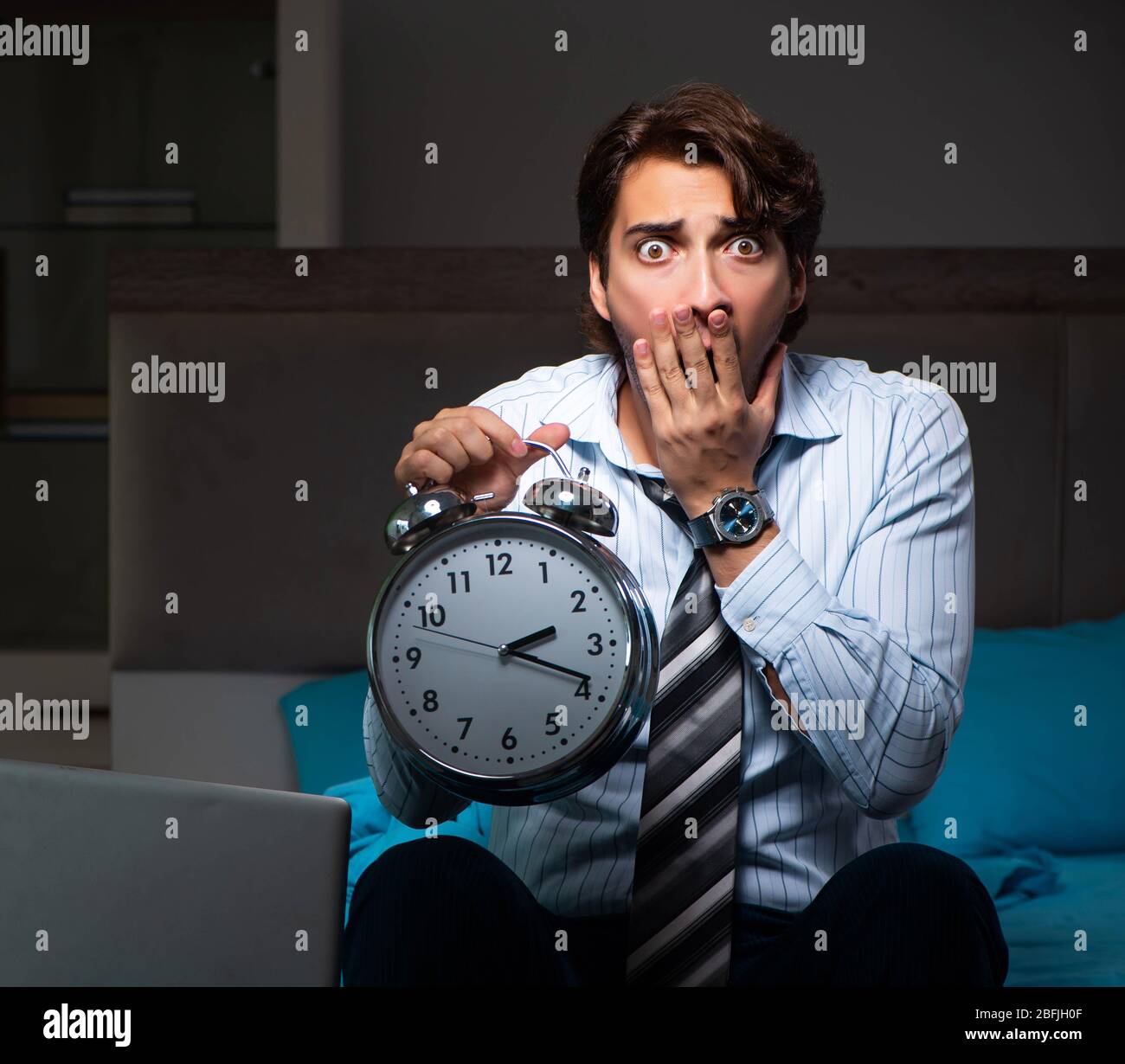 The tired businessman working overtime at home at night Stock Photo
