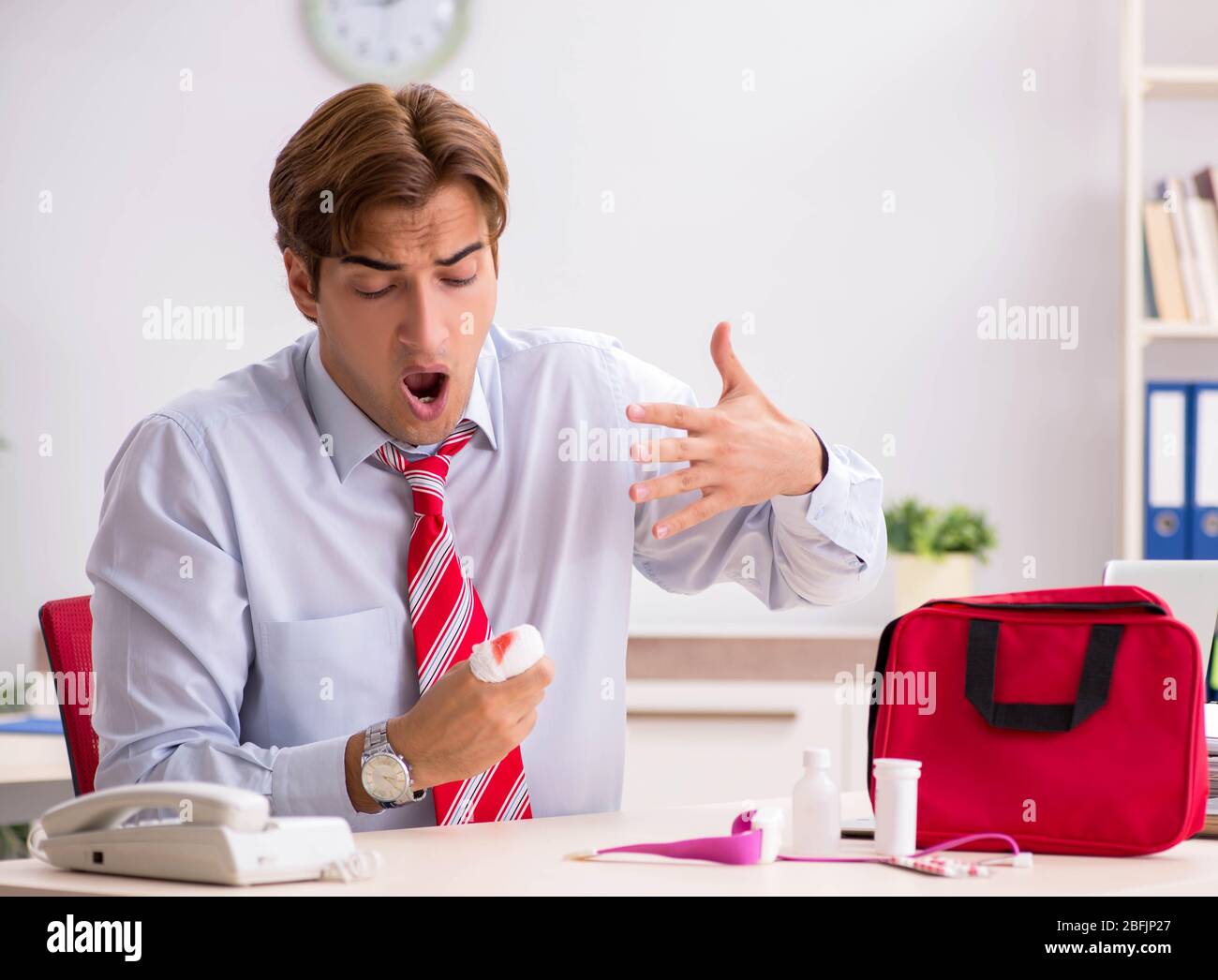 The man with first aid kit in the office Stock Photo - Alamy