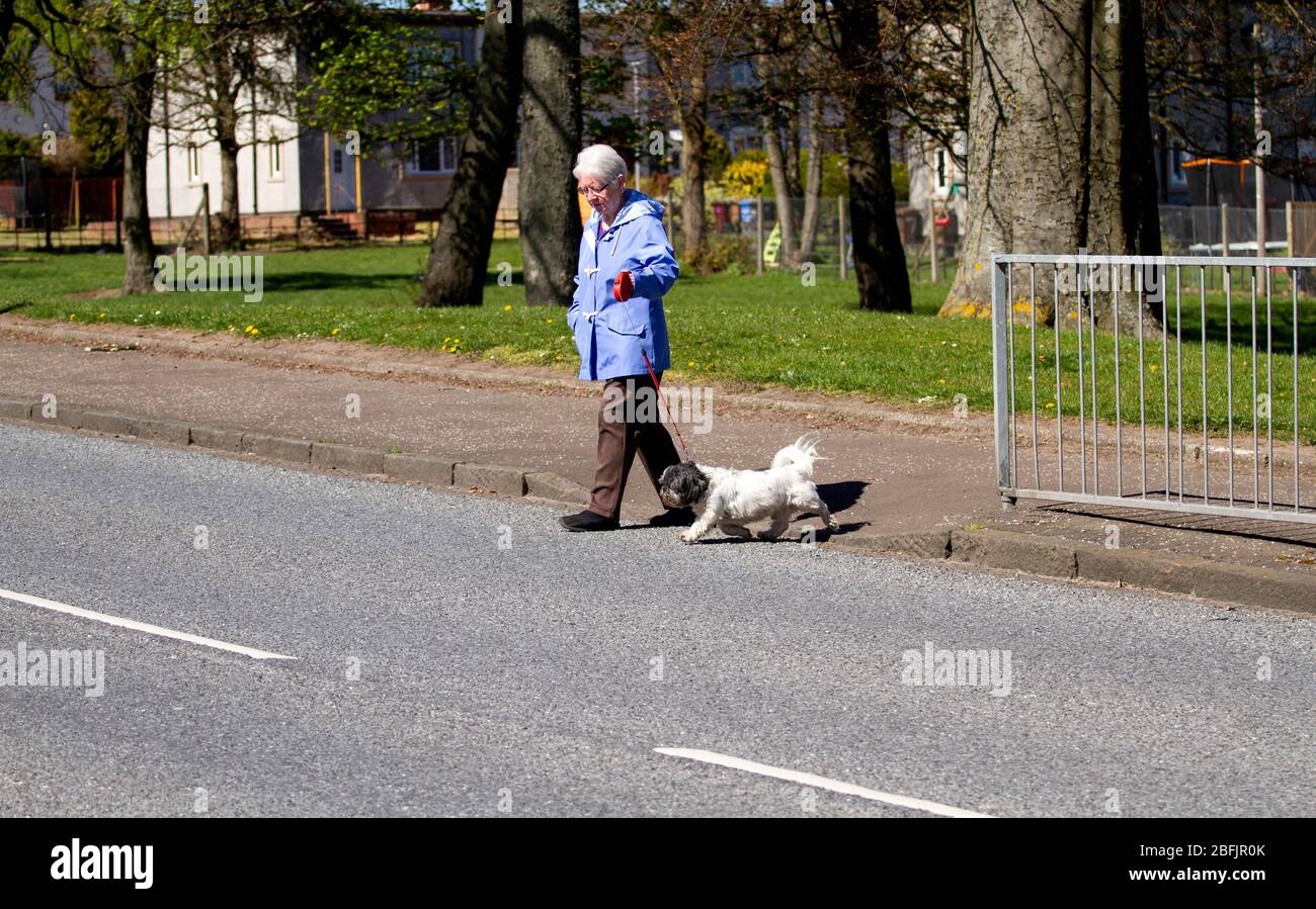 Dundee, Tayside, Scotland, UK. 19th Apr, 2020. UK Weather: A quiet Ardler Village in Dundee with some people out enjoying a lovely sunny but breezy afternoon respecting the social distancing guidelines during the lockdown restrictions continuing throughout the UK. Credit: Dundee Photographics/Alamy Live News Stock Photo
