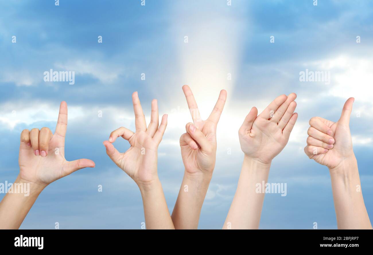 Young people's hands on sky background Stock Photo - Alamy