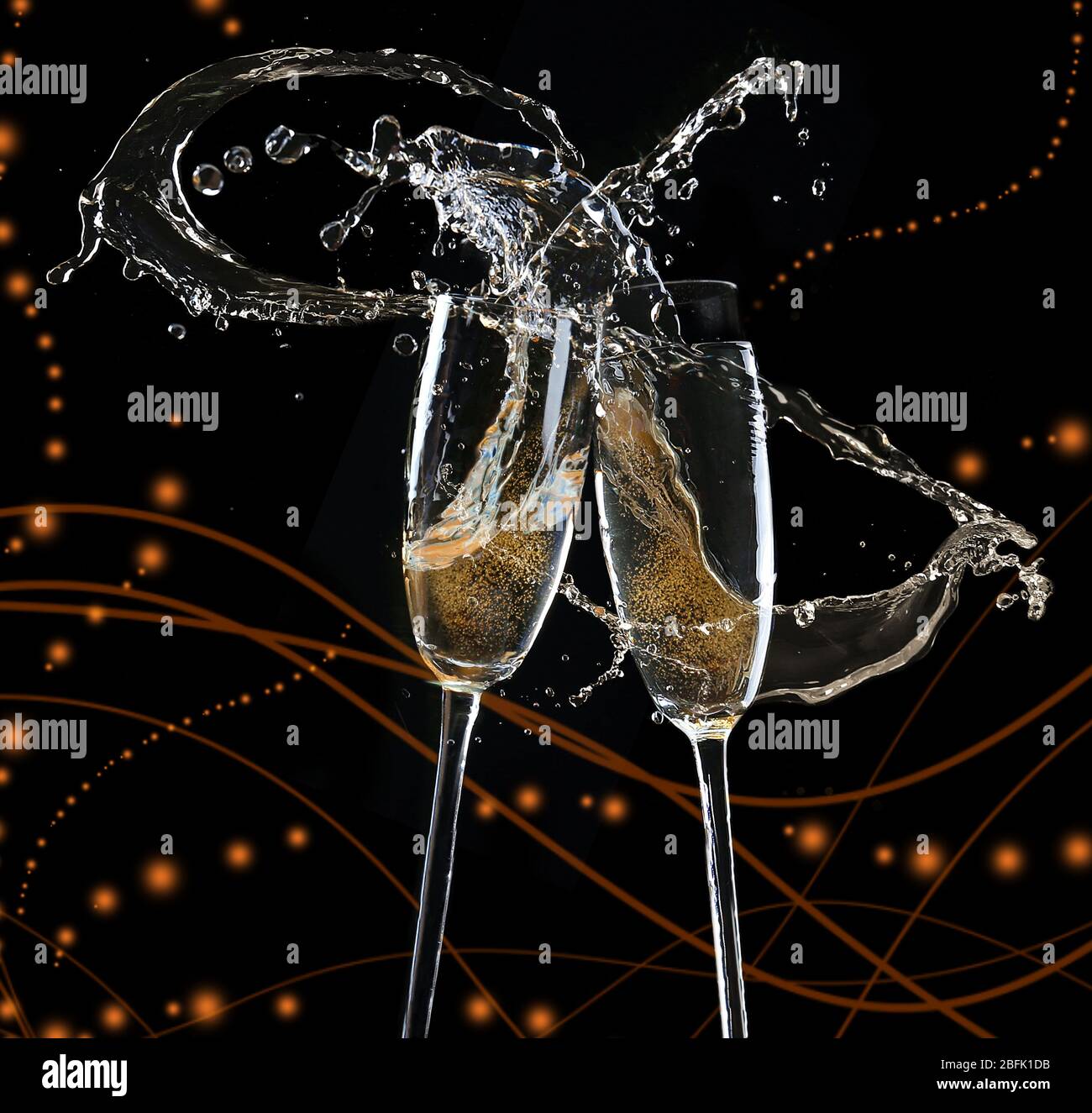 Glasses of champagne with splash, on black background Stock Photo