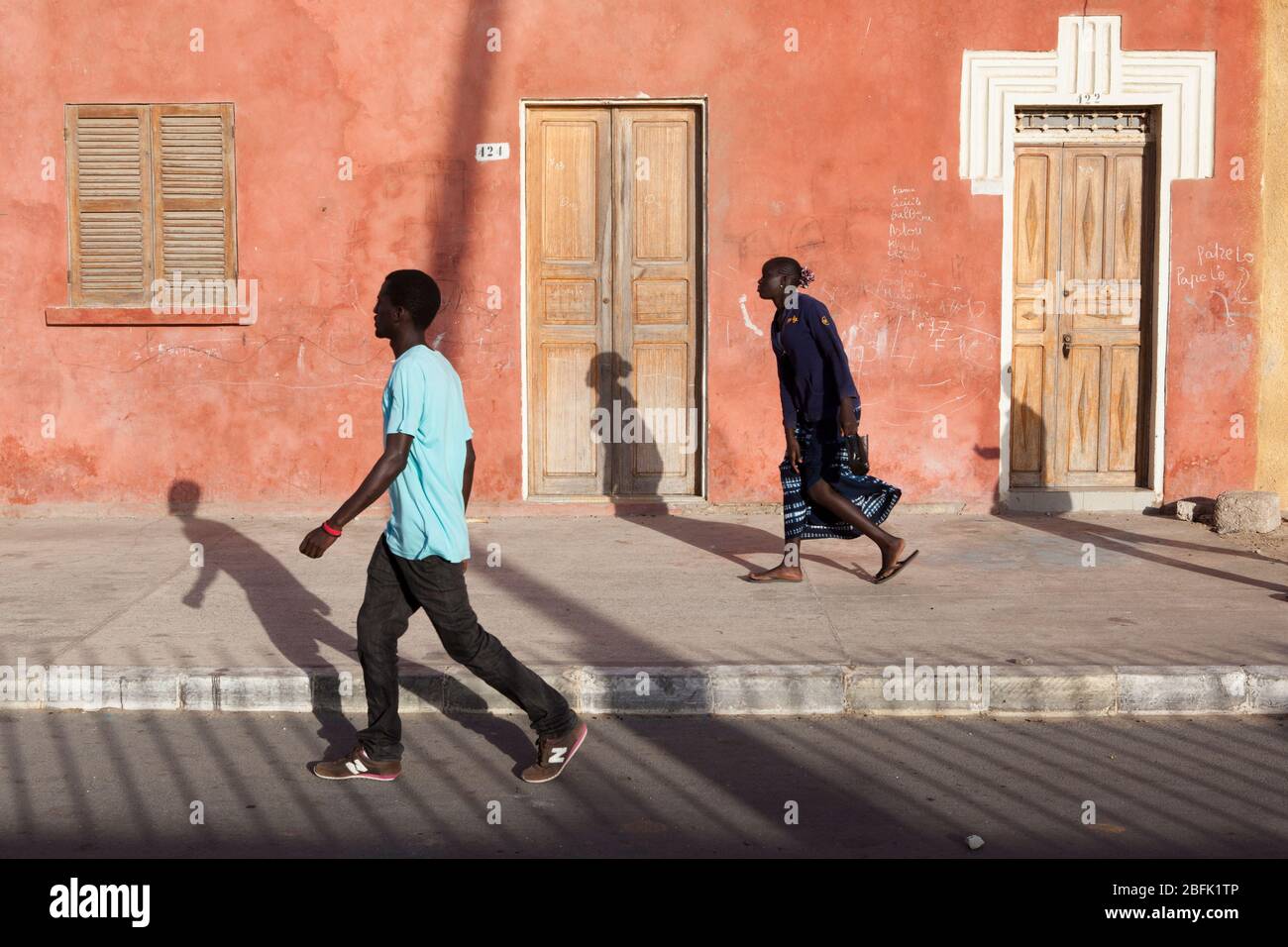 Locals stride through the old quarter of Saint Louis, Senegal. Stock Photo