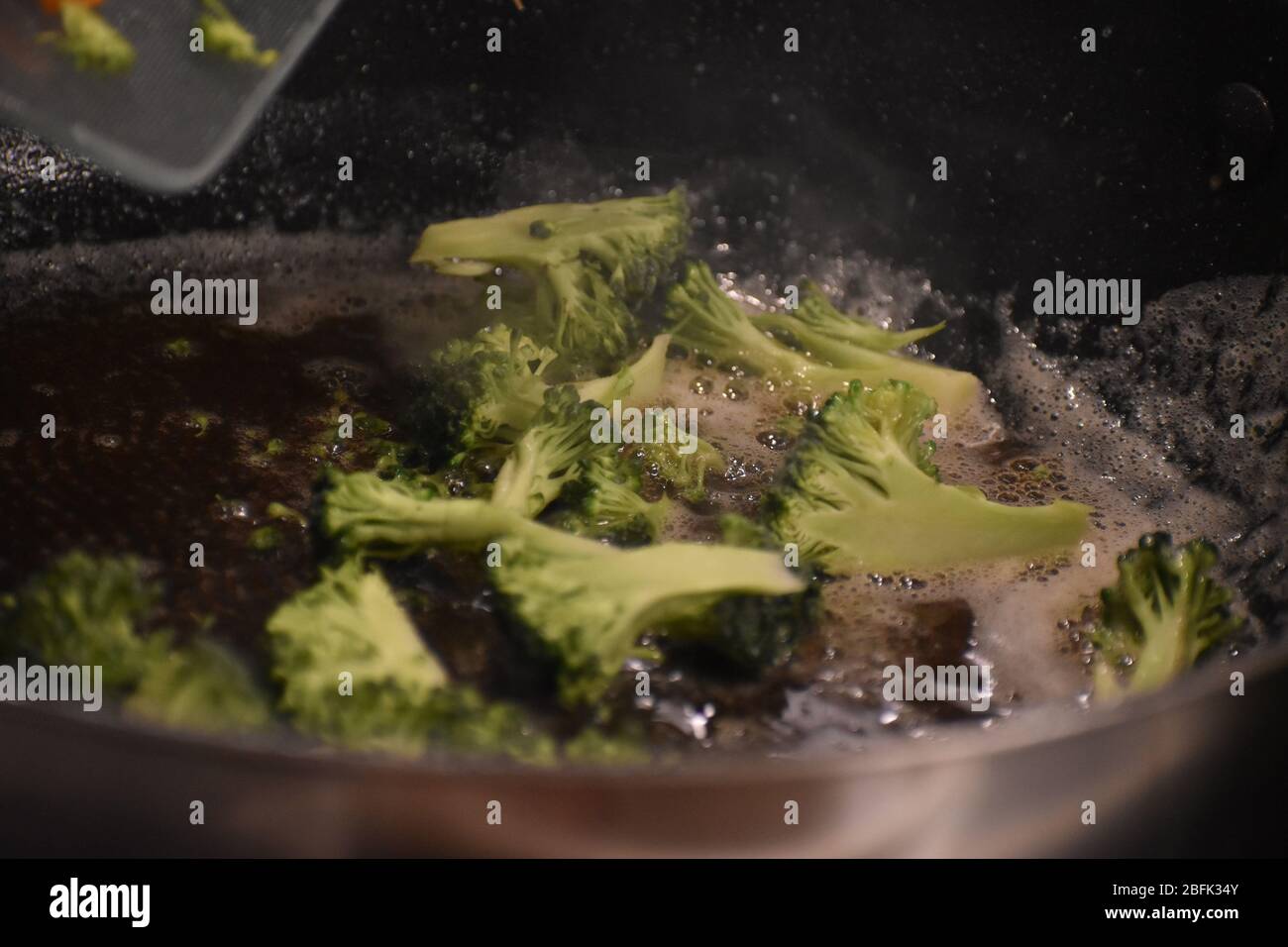 A close up of broccoli cooking in a frying pan Stock Photo Alamy