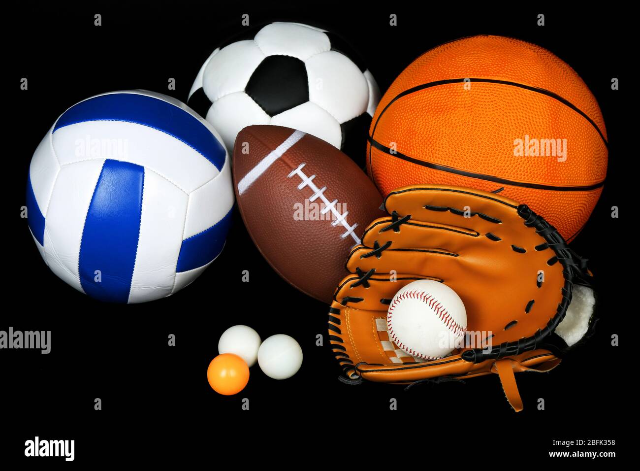Sports balls on black background Stock Photo - Alamy