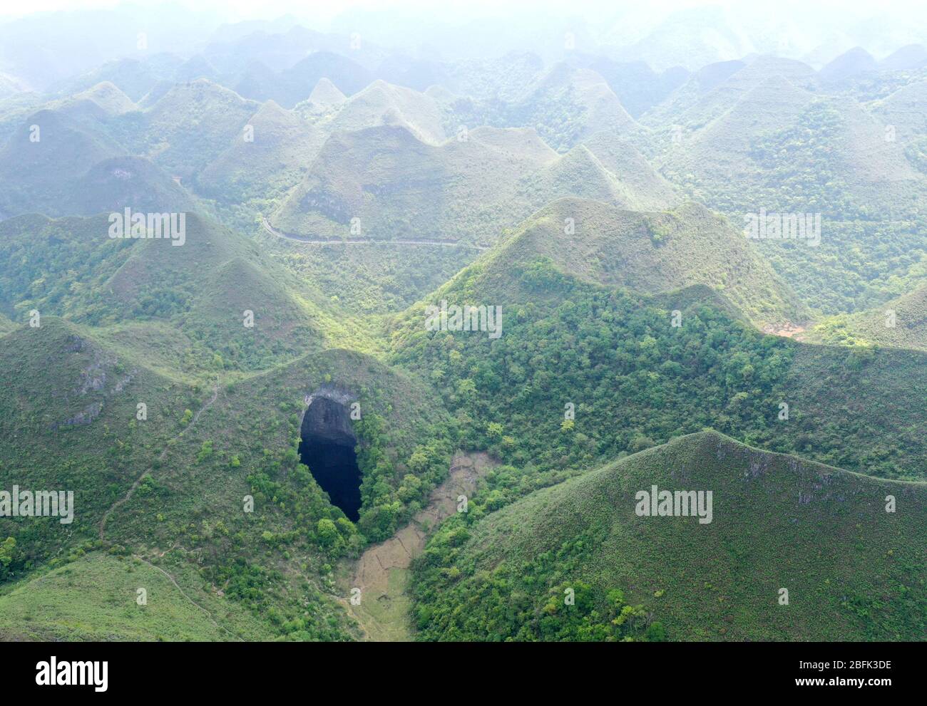 Leye. 19th Apr, 2020. Aerial Photo taken on April 19, 2020 shows a Tiankeng, or giant karst sinkhole, at Leye-Fengshan Global Geopark, south China's Guangxi Zhuang Autonomous Region. The Leye-Fengshan Geopark was added to the UNESCO's Global Geopark List in 2010. The geopark contains large subterranean rivers, natural bridges and extensive cave systems. Credit: Zhou Hua/Xinhua/Alamy Live News Stock Photo