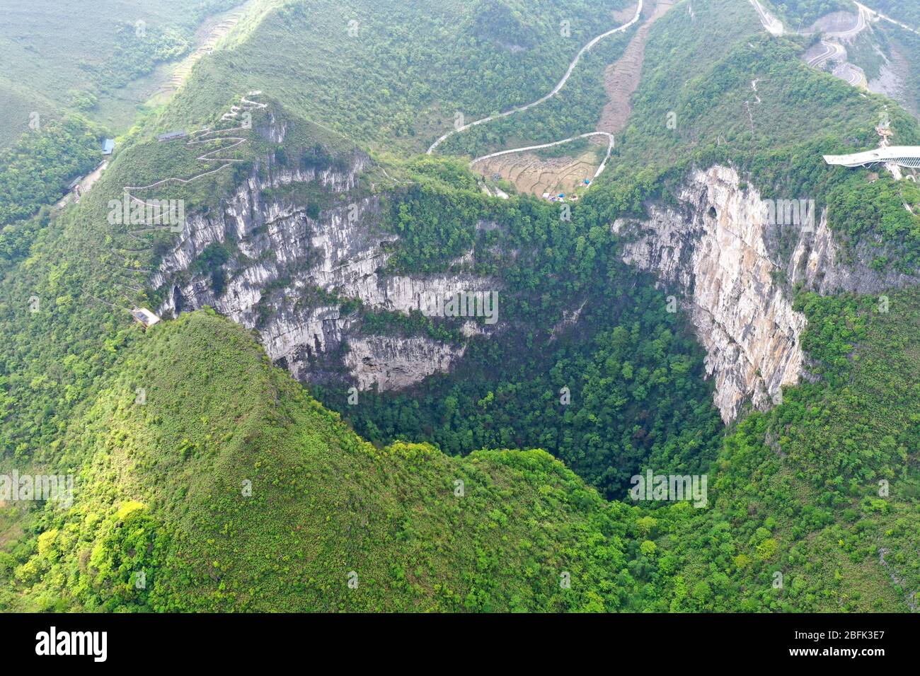 Leye. 19th Apr, 2020. Aerial Photo taken on April 19, 2020 shows the scenery of Dashiwei Tiankeng, a giant karst sinkhole, at Leye-Fengshan Global Geopark in south China's Guangxi Zhuang Autonomous Region. The Leye-Fengshan Geopark was added to the UNESCO's Global Geopark List in 2010. The geopark contains large subterranean rivers, natural bridges and extensive cave systems. Credit: Zhou Hua/Xinhua/Alamy Live News Stock Photo