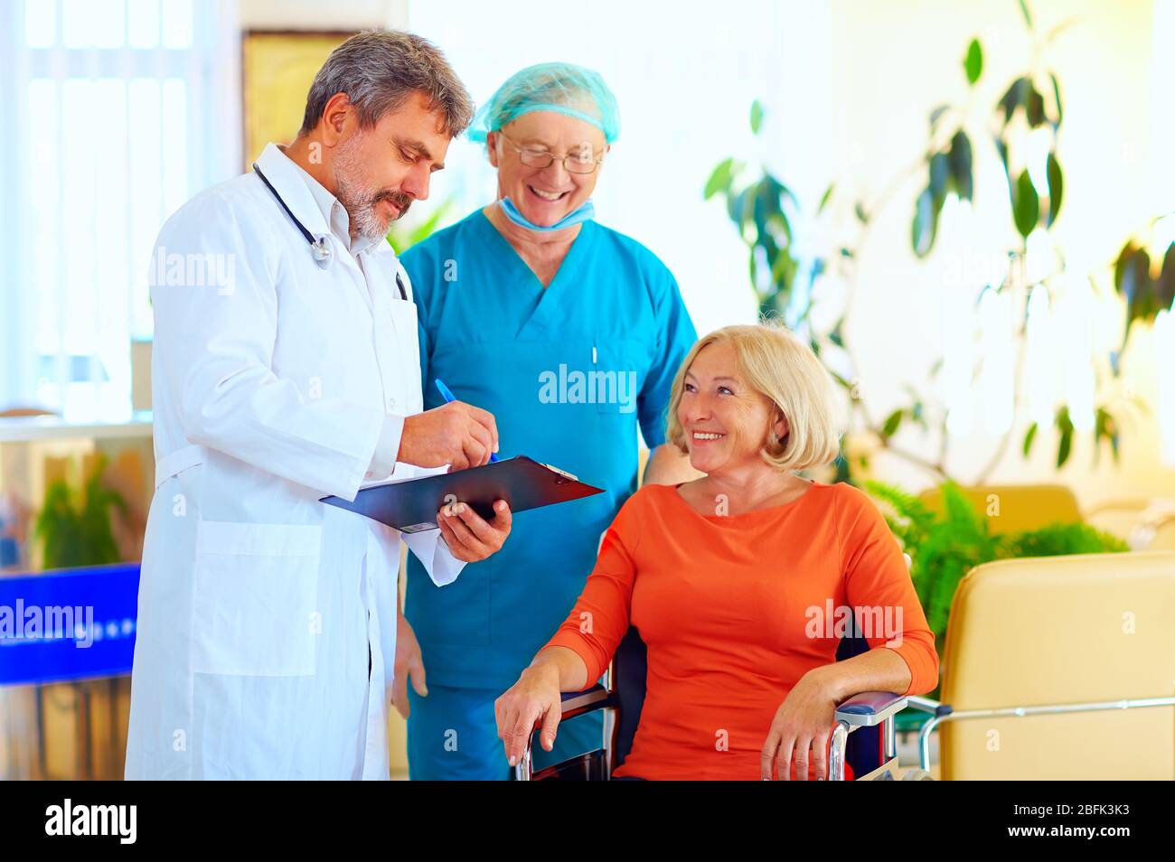 happy doctor and surgeon consulting patient about treatment before discharging from hospital Stock Photo