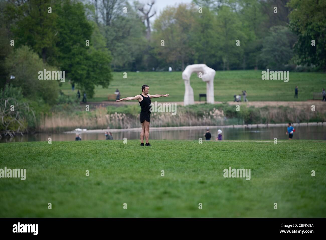 Man exercising in Kensington Park during lockdown as his daily allowance, Henry More sculpture in the background.  Health secretary, Matt Hancock, said the public must resist the urge to flout physical distancing rules to prevent tighter lockdown rules being enforced. Stock Photo