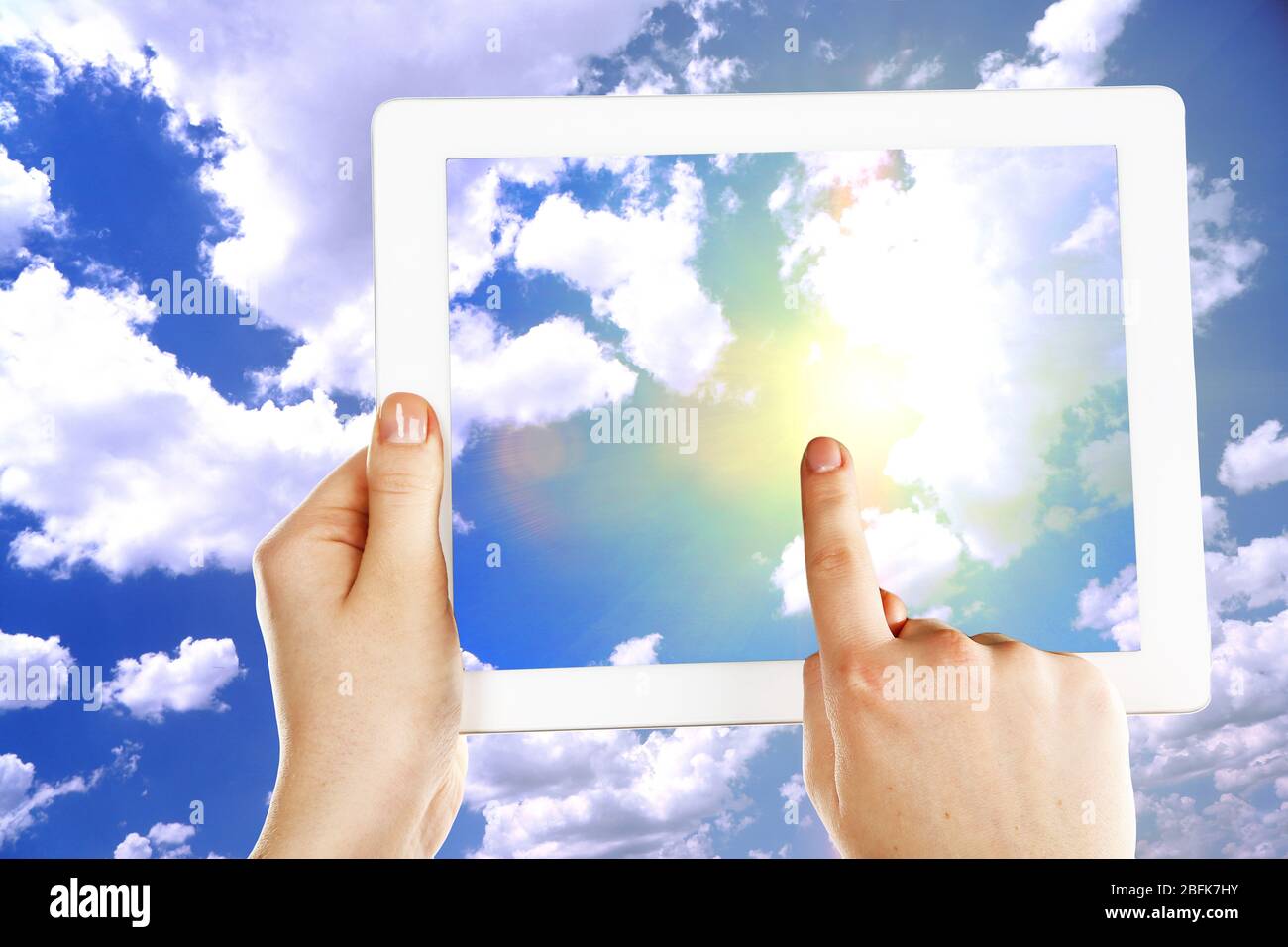 Hands holding tablet PC and pointing on screen on sky background Stock ...
