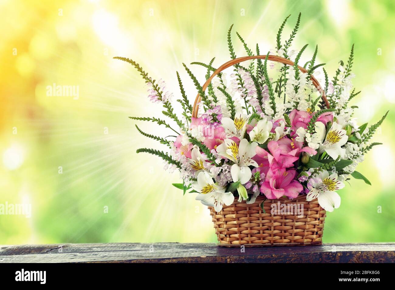 Beautiful wildflowers in wicker basket on field background Stock Photo ...