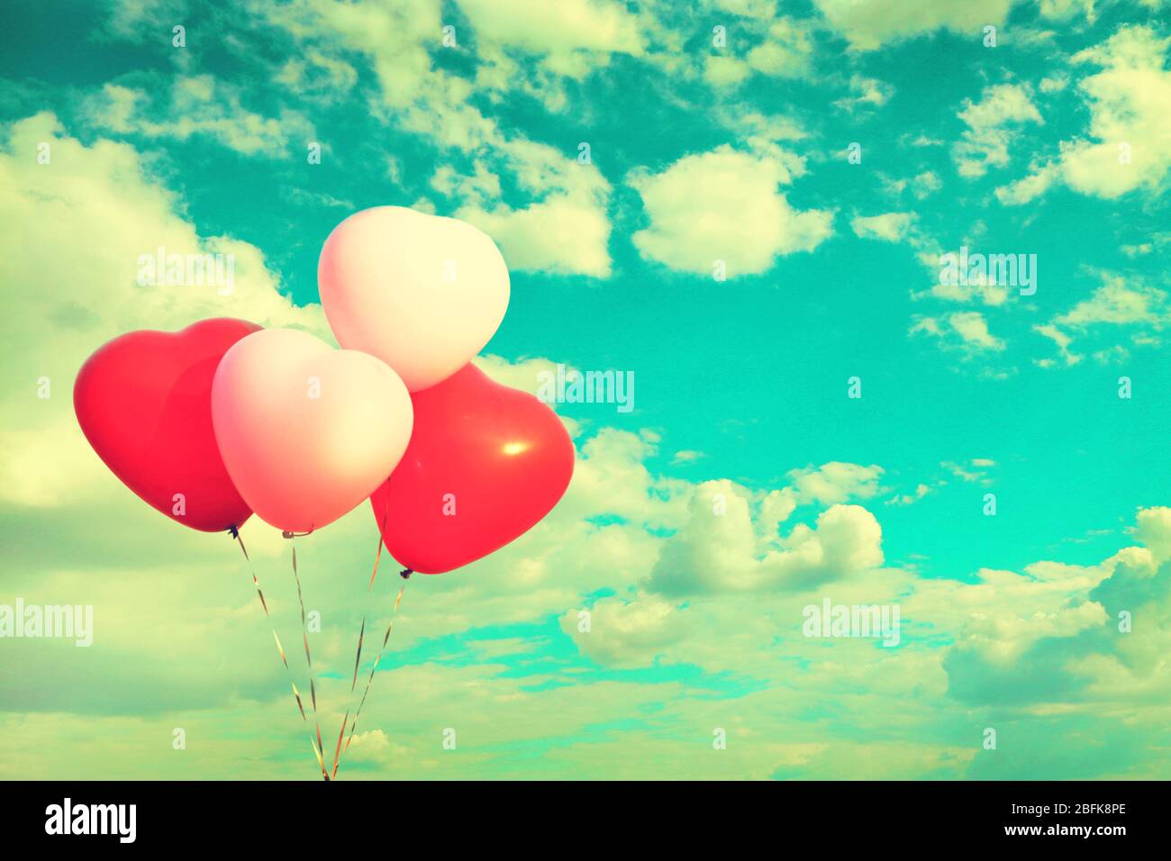 Love heart balloons on sky background Stock Photo - Alamy