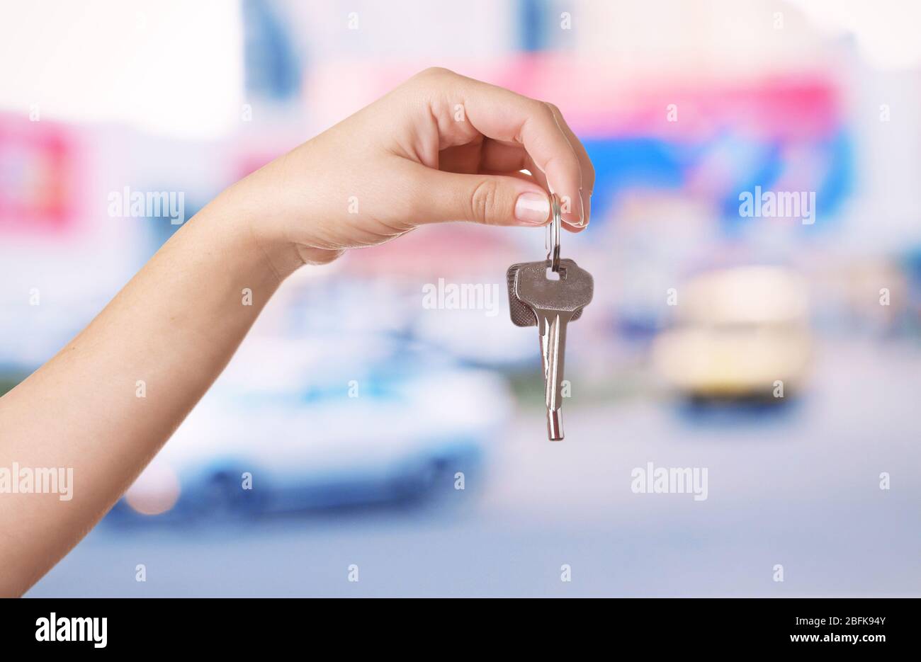 Keys in hand on blurred background store Stock Photo - Alamy
