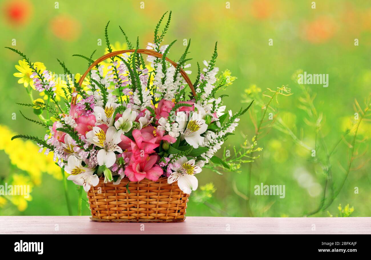Beautiful wildflowers in wicker basket on field background Stock Photo ...