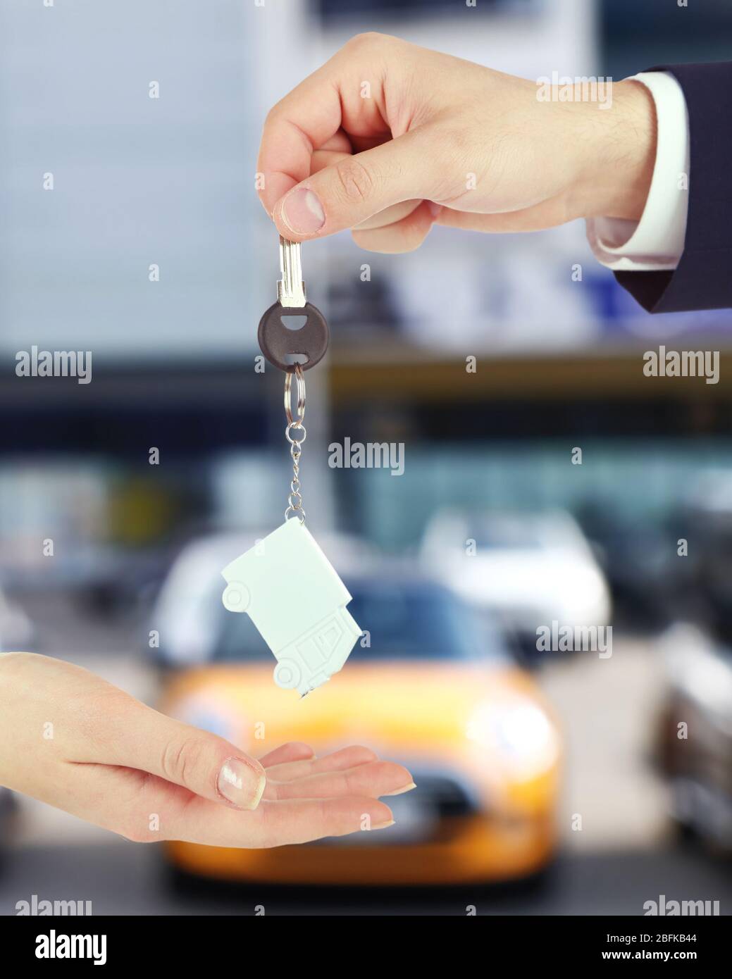 Keys in hand on blurred background store Stock Photo - Alamy