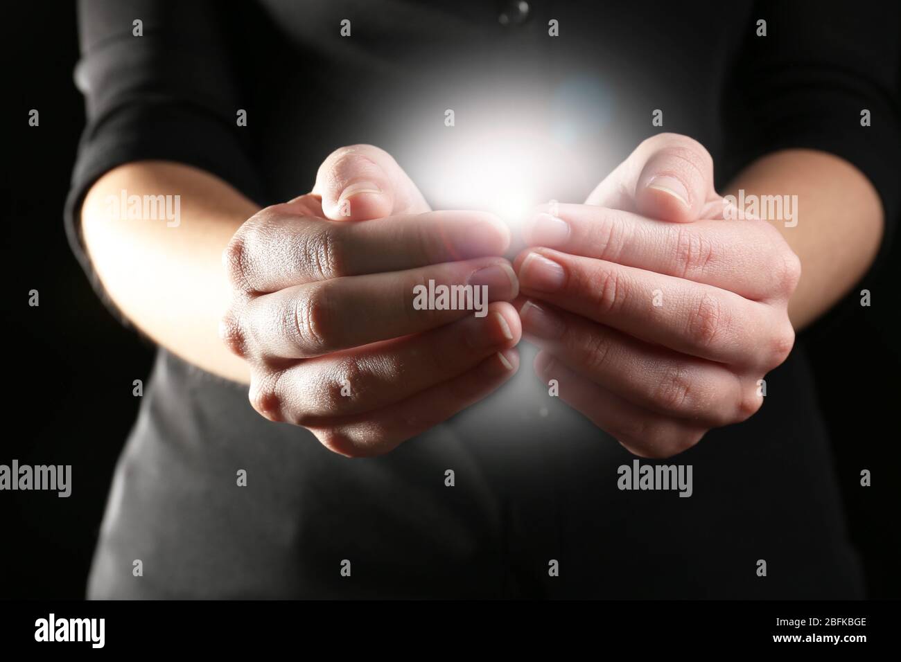 The light in young woman hands Stock Photo