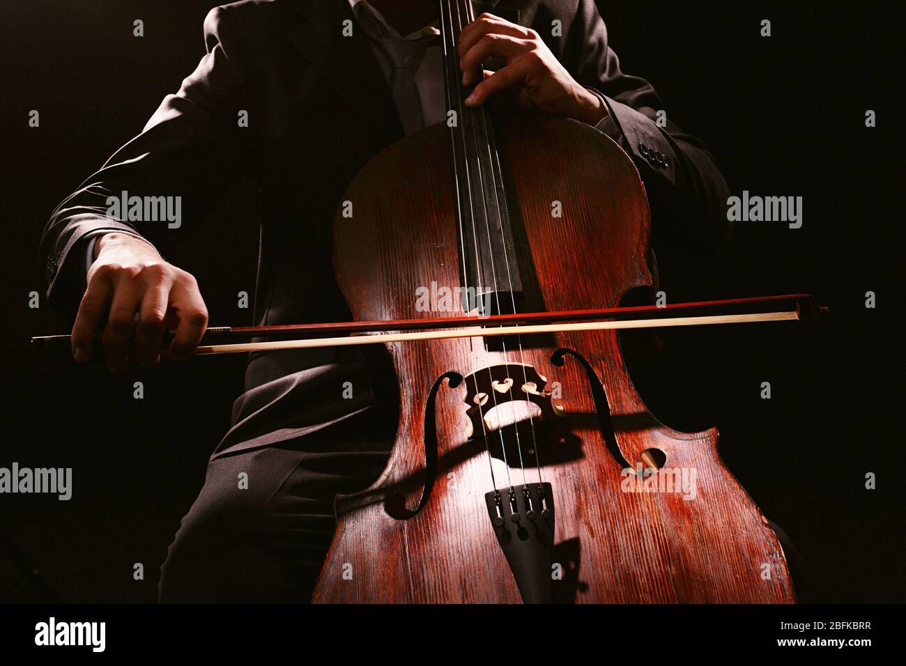 Man playing on cello on dark background Stock Photo