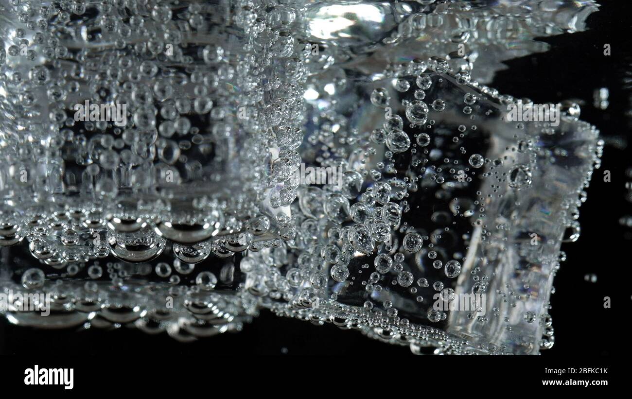 ice cube in fizzy splashing water with soda bubble Stock Photo - Alamy