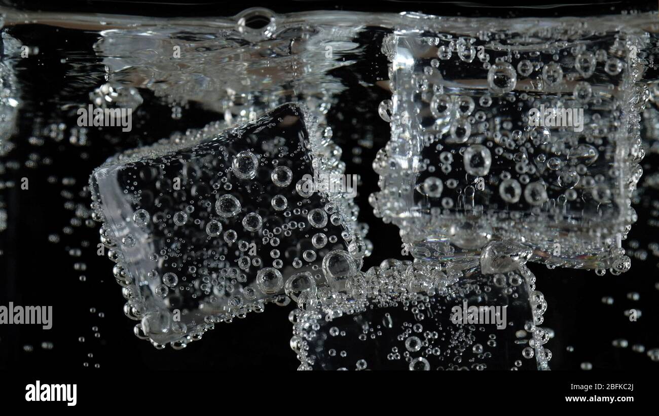 ice cube in fizzy splashing water with soda bubble Stock Photo - Alamy
