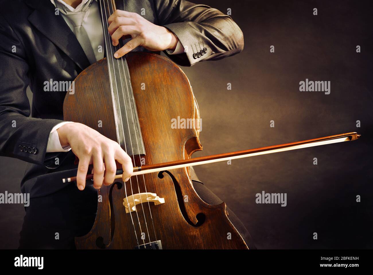 Man playing on cello on dark background Stock Photo