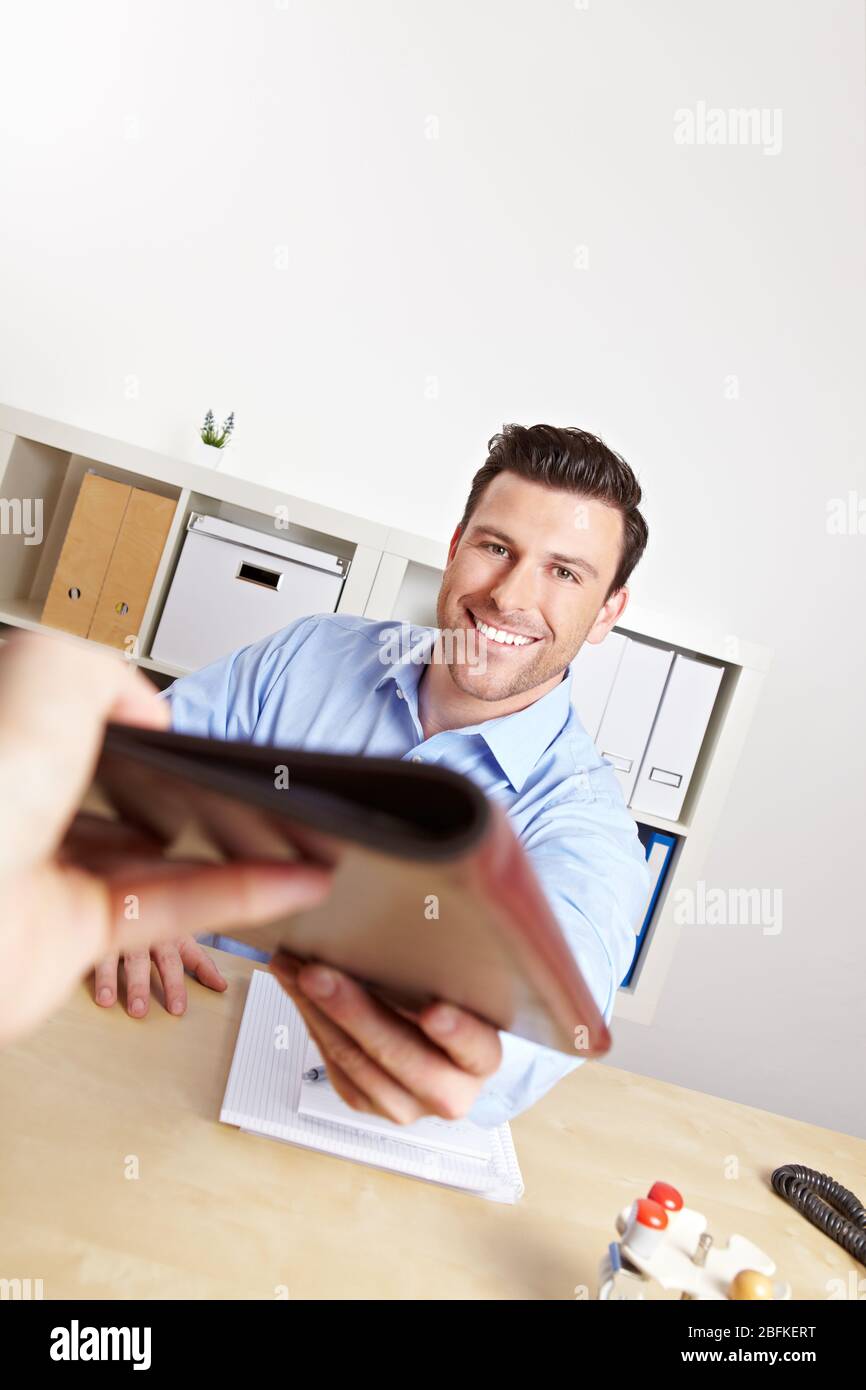 Applicants give their application folder to HR professionals in the office Stock Photo
