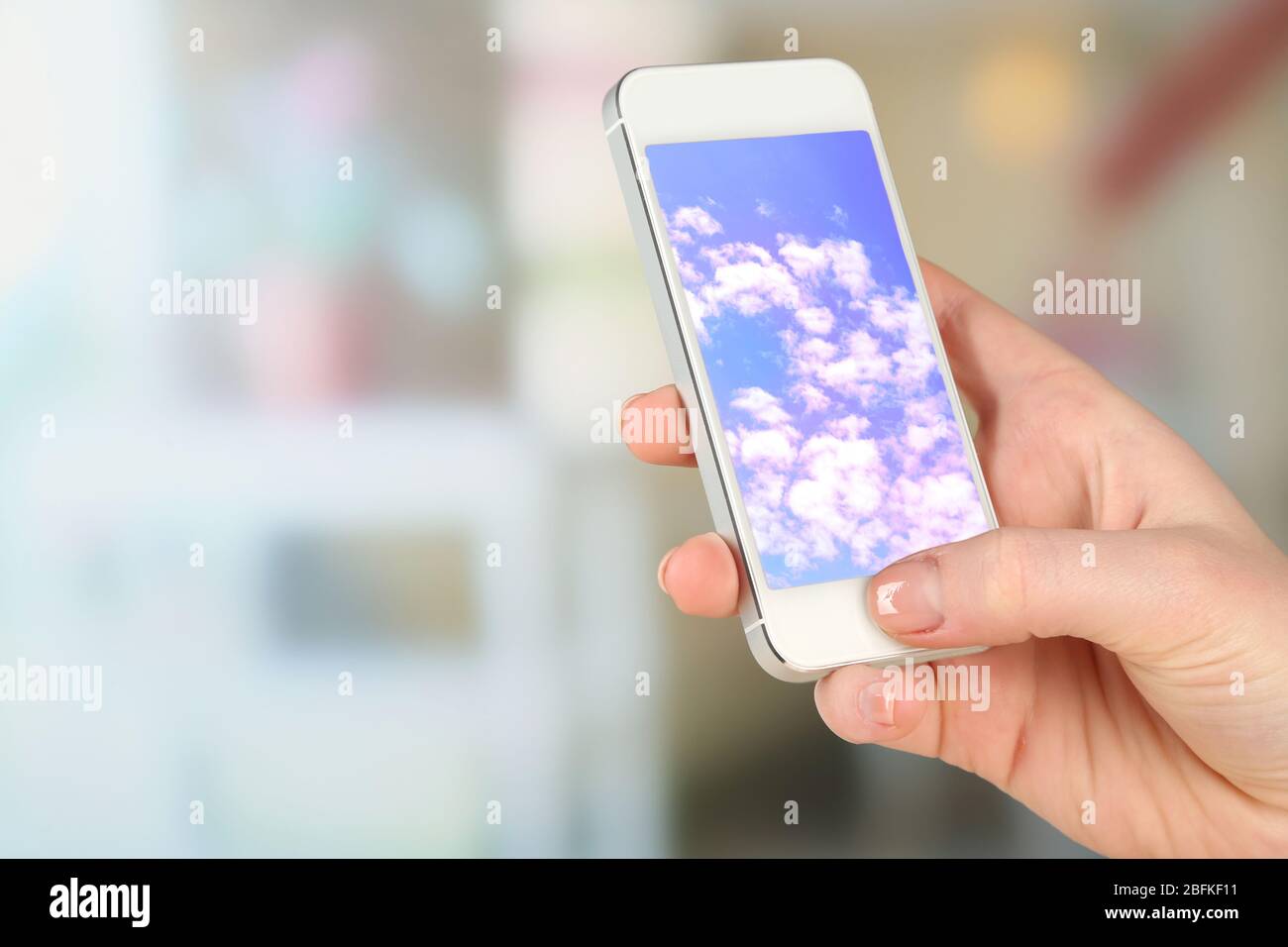Hand holding mobile smart phone with sky in screen. Cloud computing ...