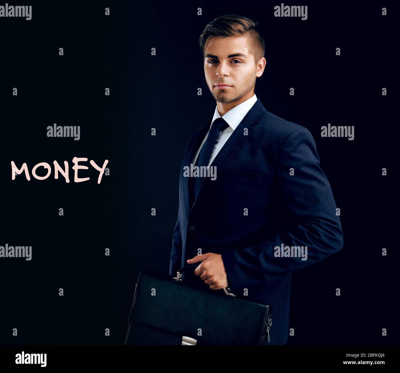 Elegant man in suit with briefcase on dark background Stock Photo - Alamy