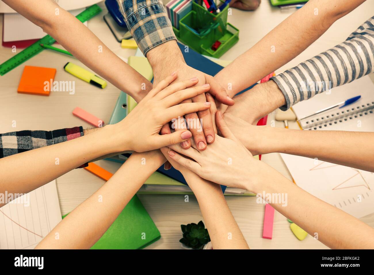 United hands of business team on workspace background top view Stock Photo
