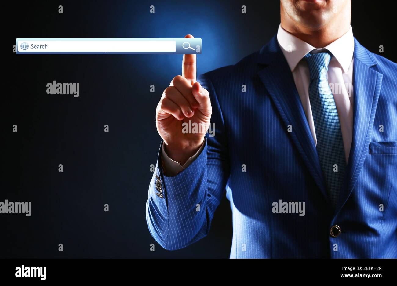 Searching system - businessman pressing search button Stock Photo