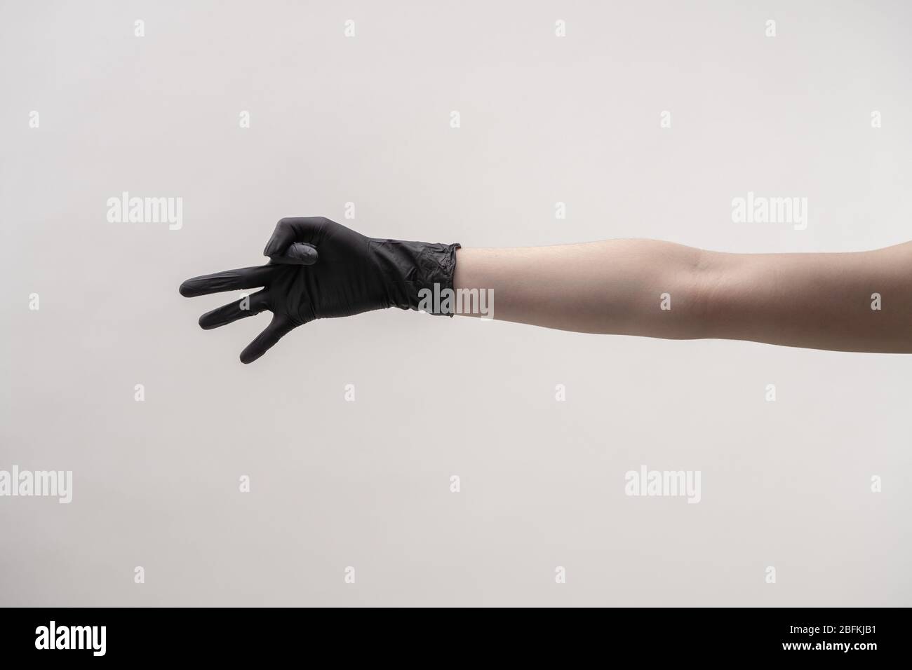 Hands in black silicone gloves on a light background. Stock Photo