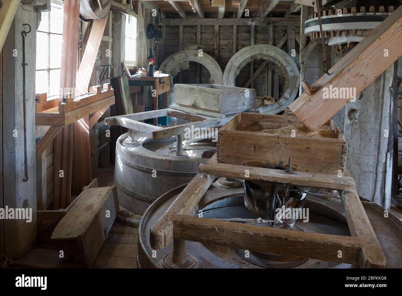 Interior of mill with grinding wheels Anglesey Abbey Cambridgeshire England Stock Photo