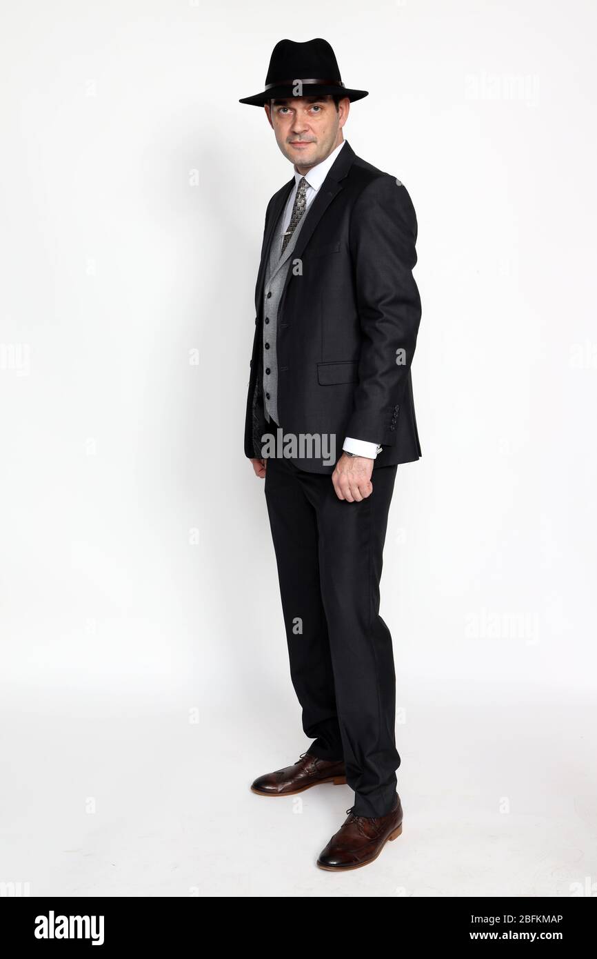 Handsome middle aged gangster man posing in studio on isolated ...