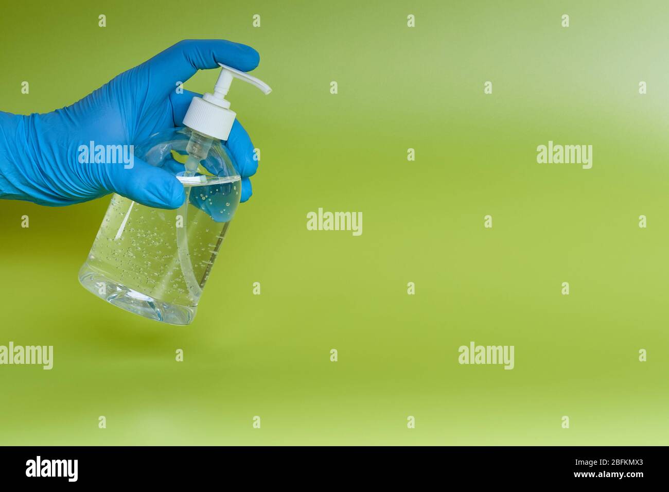 Concept: Coronavirus, Covid-19. Wallpaper. Still life hand with antiviral alcohol dispenser. green background. Stock Photo