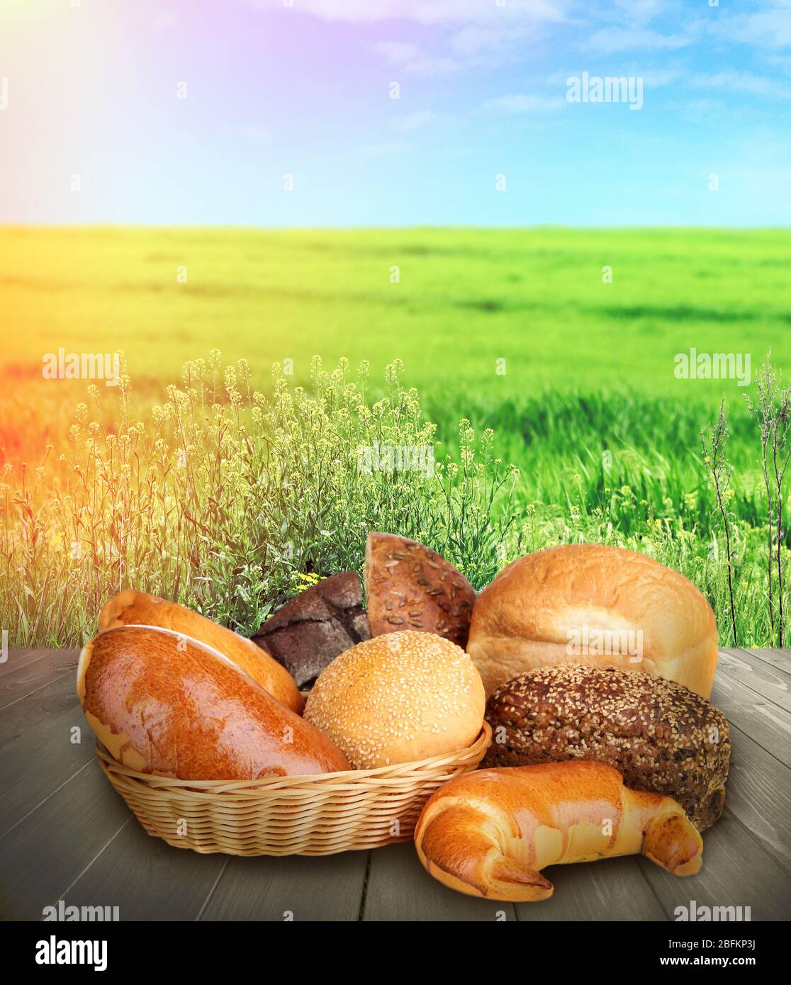 Fresh bread on wooden table, on nature background Stock Photo - Alamy