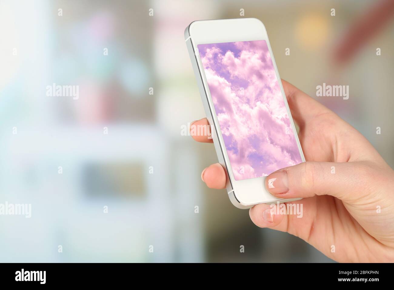 Hand holding mobile smart phone with sky in screen. Cloud computing ...