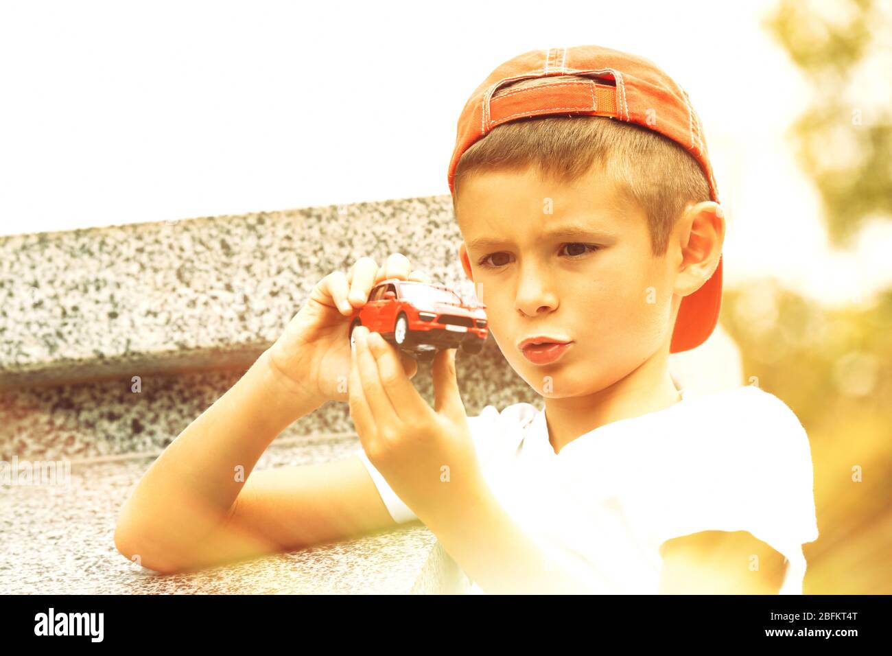 Little boy playing with toy car outside Stock Photo - Alamy